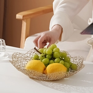 Nordic gold wire fruit basket with wavy edges displayed on a table in a bright living room