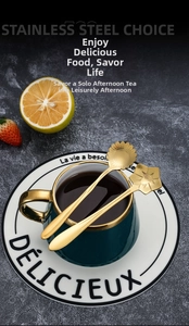 Detail of gold stainless steel dessert spoons featuring cherry blossom and sunflower shapes