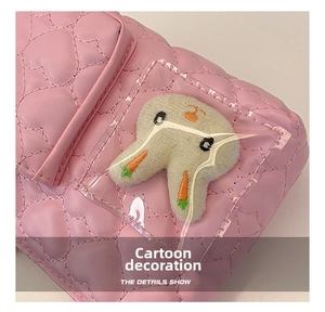 Macro delle cuciture a cuore trapuntate rosa e tasca in PVC trasparente con peluche coniglio