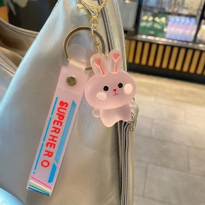 Porte-clés lapin rose mignon en résine avec lanière violette sur un sac en métal argenté