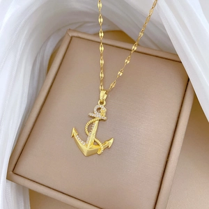 Vue macro d'un collier ancre plaqué or avec détails en zircons et texture de corde tressée