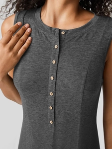 Detalle de un vestido de punto gris oscuro sin mangas con pequeños botones de madera