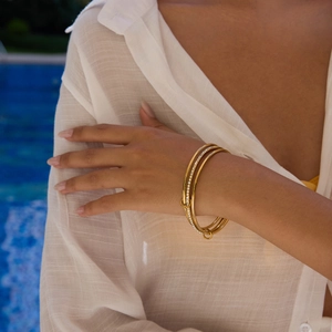 Close-up of three-piece 18K gold-plated stainless steel bangles with white zircon inlays