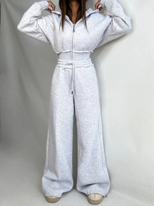 Women's grey two-piece tracksuit featuring a cropped zip-up hoodie and wide-leg joggers
