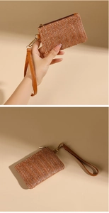Detail view of woven brown coin purse with wrist strap and smooth gold hardware zipper