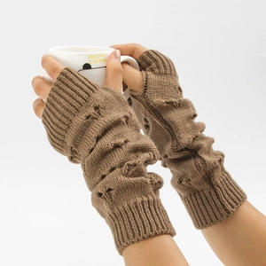 Detailed knit texture of long brown fingerless arm warmers held over a coffee cup