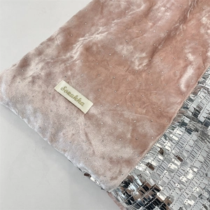 Close-up of pink velvet fabric featuring shimmering glitter and silver sequins texture