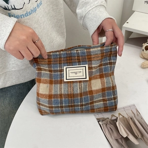 Detailed close-up of retro plaid wool makeup bag with PLEASANT TIME woven label