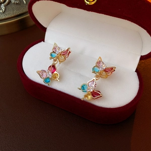 Nahaufnahme goldener Schmetterlingsohrringe mit bunten Zirkonias in roter Samtbox