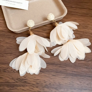 Detail of floral chiffon tassel earrings with ivory fabric petals and woven rose studs