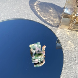 Détail d'une pince à cheveux en acétate fait main avec texture marbrée sur miroir