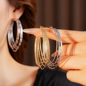 Close-up of multilayer hoop earrings in gold and silver finish with fine metal texture