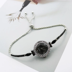 Detail view of silver quartz watch with black gems and adjustable drawstring closure