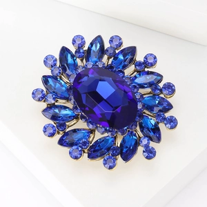 Macro view of blue crystal flower brooch with large oval gemstone on gold base