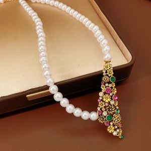 Détail du collier fleur vintage avec perles et cristaux dans son écrin à bijoux