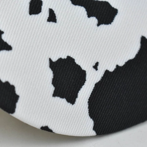 Close-up of black and white cow print texture on high-quality twill cotton baseball cap