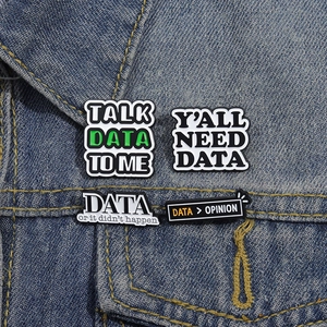 Detailed view of data-themed PVC pins on denim fabric with office humor slogans