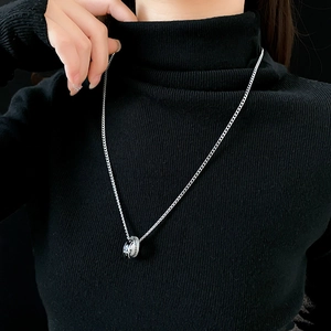 Détail du collier à lettres imbriquées avec zircon et goutte d'émail noir sur mannequin