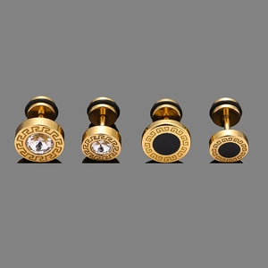 Detailed macro of gold-plated studs with Greek key patterns and cubic zirconia stones