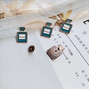 Front and back views of a blue enamel perfume bottle brooch with gold metal details