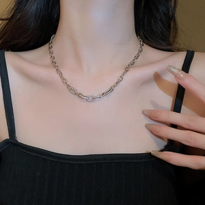 Detailed view of silver curb chain necklace featuring a zircon-encrusted rectangular buckle