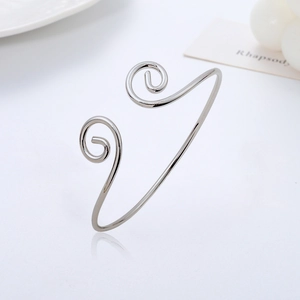 Macro detail of silver adjustable cuff bracelet featuring a classic spiral design finish