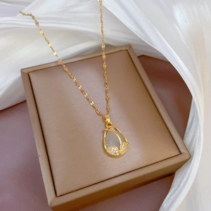 Elegant gold tulip pendant necklace with cat-eye stone and cubic zirconia on silk fabric