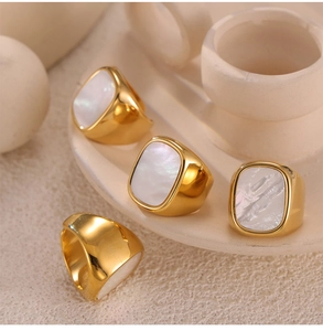 Detail of four gold-plated titanium rings featuring elegant white mother of pearl inlay