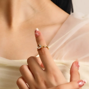 Close-up of elegant gold ring with a large heart-shaped zircon on a model's hand