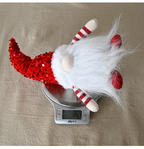 Detail showing Christmas gnome with red sequins on scale weighing 86.4 grams