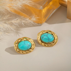 Détail de boucles d'oreilles turquoise avec bordure tressée dorée sur un fond élégant