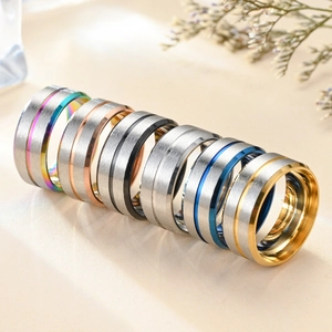 Close-up of 8mm brushed stainless steel rings in multi-color finishes and textures