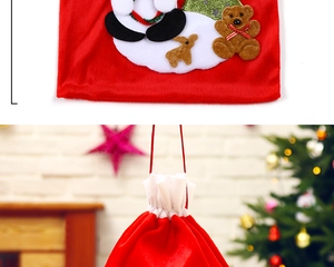 Detail of red velvet Christmas gift bag with Santa and reindeer plush appliques