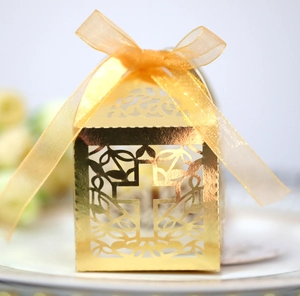 Detailweergave van de gouden holle geschenkdoos met kruispatroon en geel satijnen strik