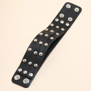 Detail of punk leather wristband with triple rows of silver rivets and snap button closure