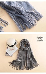 Detail shot of medium grey plaid cashmere scarf texture with long fringe tassels