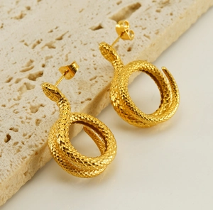 Macro shot of 18K gold snake earrings showing detailed scale texture and craftsmanship