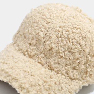 Close-up of beige faux shearling baseball cap showing thick fuzzy fleece texture