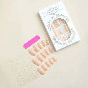 Close-up of French tip press-on nail kit with nude base and yellow edges plus accessories