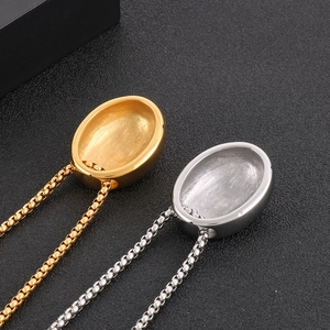 Polished gold and silver waterdrop oval pendants with box chains on black background