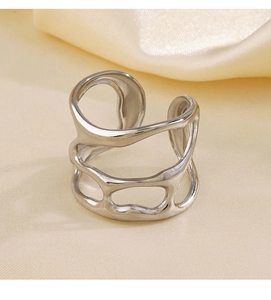 Macro view of silver stainless steel ring with irregular hollow design on satin background