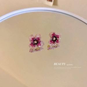 Exquisite gradient pink and purple flower stud earrings with golden center on warm beige