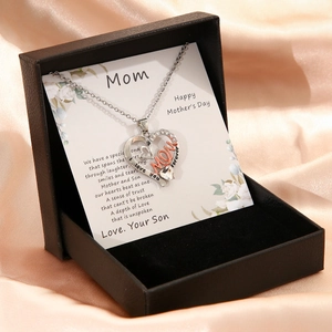 Macro detail of heart necklace with Mom engraving in a premium gift box