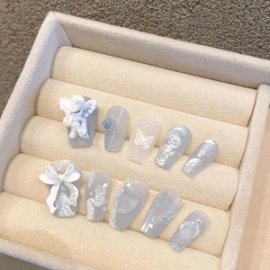 Premium misty blue handmade press-on nails with 3D angel and rose charms in a box