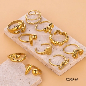 Detailed set of ten gold-plated bow and heart rings displayed on textured stone blocks