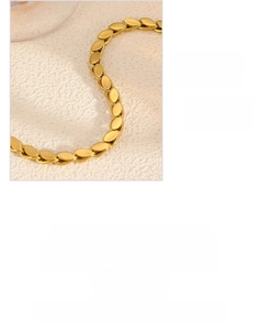 Vista macro dettagliata del bracciale in acciaio al titanio placcato oro 18k con maglie a foglia