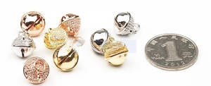 Macro shot of cubic zirconia bell charms in gold, rose gold and silver for DIY jewelry