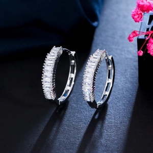 Detail of silver hoop earrings with baguette cut cubic zirconia in a pave setting
