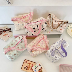 Flat lay of lace-trimmed canvas bags with cat, rabbit, and floral prints on steps