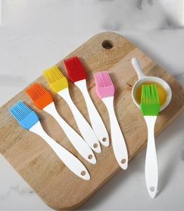 Set of six colorful silicone oil brushes on wooden board for baking and grilling